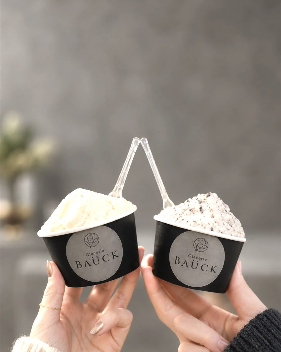 2つのGlacerie BAUCKのジェラートを持つ手